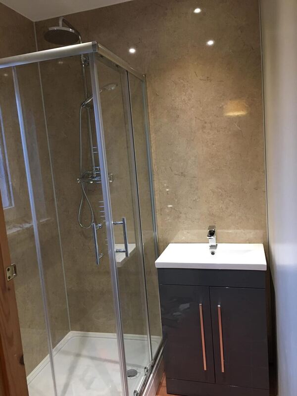 Refitted shower room with corner enclosure and vanity unit